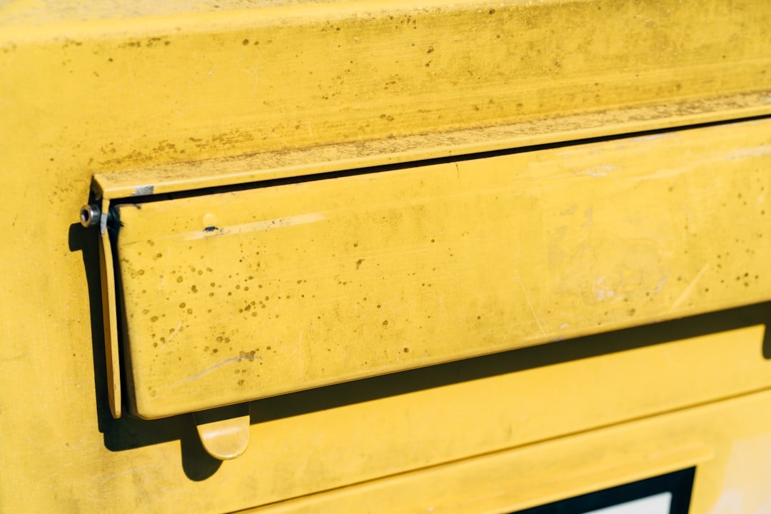 Close-up of a yellow mail drop box