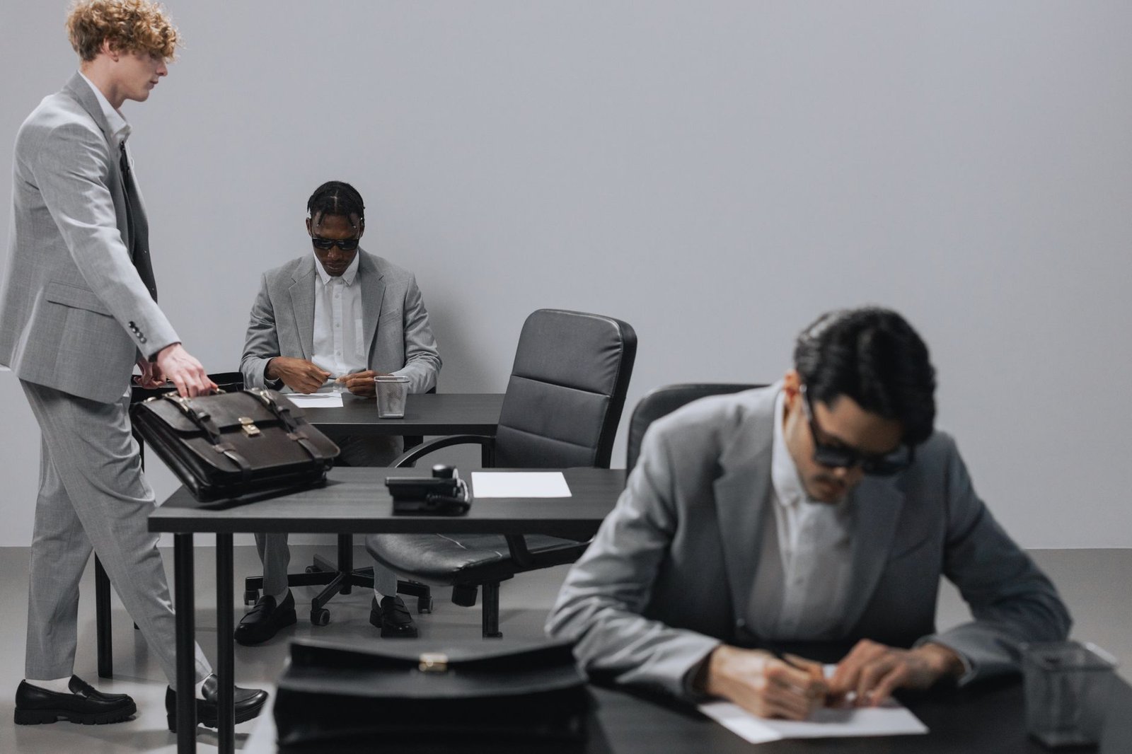 Business office with diverse employees in gray suits working at desks in an indoor setting. — Best Forex EA Tools Helping Tra